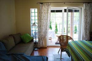 a living room with a couch and a sliding glass door at Dom wakacyjny Nasze morze in Kopalino