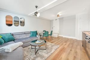 a living room with a gray couch and a table at Cuckoo Rooms in Colchester