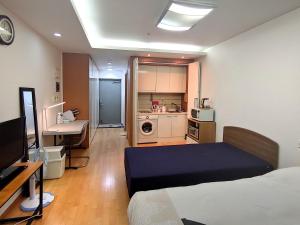 a bedroom with a bed and a kitchen with a sink at Khan Residence in Seoul