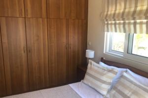 1 dormitorio con 1 cama con armarios de madera y ventana en 180° view maisonette No.1 en Poros