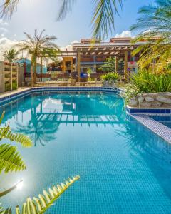 uma piscina com um resort ao fundo em Pousada Blue Viking na Praia do Francês