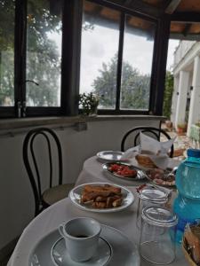 a table with plates of food and a cup of coffee at Villa Dei Romani - Country House in Guidonia