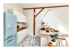 a kitchen with a blue refrigerator and a table at Sunny Apartment at the Heart of Old Town in Krakow