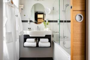 y baño con lavabo, ducha y espejo. en Hotel Plaza Elysées, en París