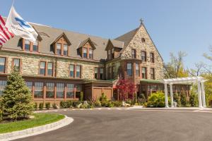 een groot huis met een Amerikaanse vlag ervoor bij The Abbey Inn & Spa in Peekskill