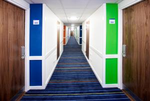 a hallway in an office building with blue and green walls at Holiday Inn Express London City, an IHG Hotel in London