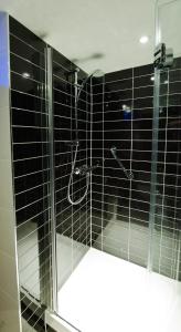 a bathroom with a shower with black tile at Holiday Inn Express London City, an IHG Hotel in London