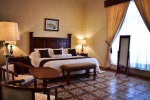une chambre d'hôtel avec un lit, une table et des chaises dans l'établissement Hotel Boutique La Albertina, à San Martín Texmelucan de Labastida