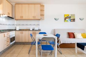 a small kitchen with a table and chairs and a bed at LOS ANGELES Holiday Home in Los Cristianos