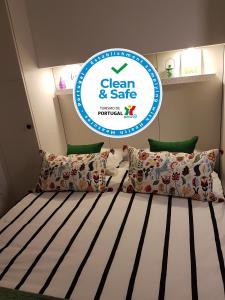 Schlafzimmer mit einem Bett mit einem Schild, auf dem sauber und sicher steht in der Unterkunft Porto Belo Clérigos in Porto