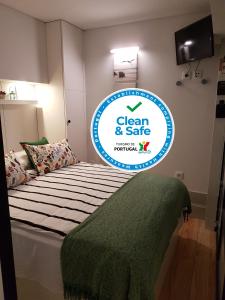 ein Schild für ein sauberes und sicheres Zimmer mit einem Bett in der Unterkunft Porto Belo Clérigos in Porto