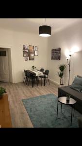 ein Wohnzimmer mit einem Sofa, einem Tisch und Stühlen in der Unterkunft Leutzsch apartment in Leipzig