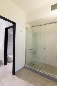 a glass shower in a bathroom with a toilet at Be Hollywood! in Buenos Aires
