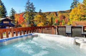 a hot tub on a deck with a wooden fence at Chalets Alpins - 12 Chemin Alpin in Stoneham