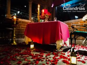 una mesa con un mantel rojo y rosas en el suelo en Las Calandrias, en Atlixco
