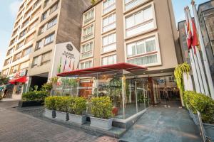 a store front of a building with potted plants at La Paz Apart Hotel in Lima +33 photos