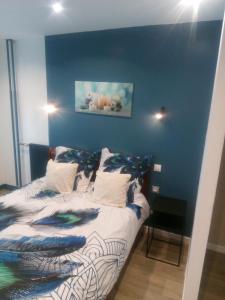 - une chambre avec un lit et un mur bleu dans l'établissement Studio 28m² au pied de la défense, à Courbevoie