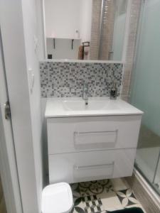ein Badezimmer mit einem weißen Waschbecken und einem Spiegel in der Unterkunft Studio 28m² au pied de la défense in Courbevoie