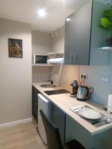 a kitchen with blue cabinets and a counter top at Studio 28m² au pied de la défense in Courbevoie