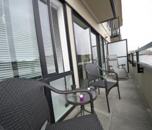 a balcony with chairs and windows on a building at Urban Den in Victoria