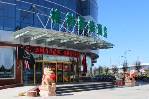 a building with a lion statue in front of it at GreenTree Inn Zhangjiakou Yu County Bus Station Business Hotel in Xiaowa