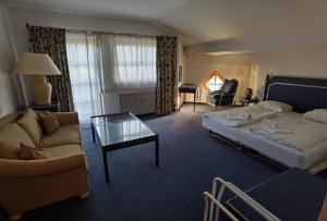 a hotel room with a bed and a couch and a table at Select Apartment Top 13by Alpina in Piesendorf