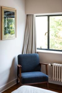 a room with a blue chair and a window at B&B Four Corners in Ghent