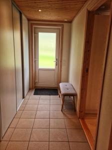 an empty hallway with a door and a bench at Three bedroom vacation home in Við Gjógv