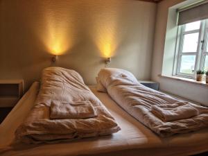 a bed with a blanket on it in a room at Three bedroom vacation home in Við Gjógv