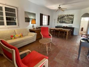 uma sala de estar com um sofá, cadeiras e uma mesa em Beach House - Tavira Island em Tavira