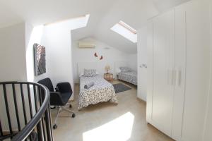 ein weißes Zimmer mit 2 Betten und einem Stuhl in der Unterkunft Desconnectar Malgrat de Mar in Malgrat de Mar