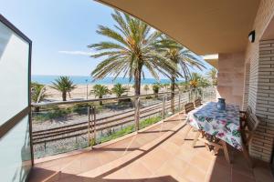einen Balkon mit einem Tisch und Strandblick in der Unterkunft Desconnectar Malgrat de Mar in Malgrat de Mar