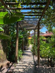 a wooden pathway with a pergola in a garden at Pousada Sossego in Ilha de Boipeba