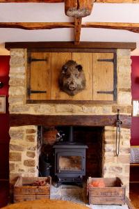 a stone fireplace with a animal head on top of it at The Barrington Boar in Ilminster