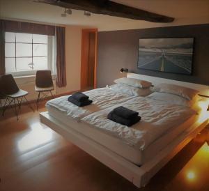 een slaapkamer met een groot bed en 2 handdoeken bij Roastineer Hotel in Battenberg