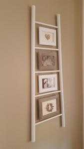 a shelf with framed pictures on a wall at A casa di Jacqueline in Rovereto