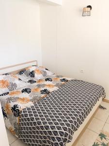 een slaapkamer met een bed met een zwart-wit dekbed bij Lagon Sainte-Anne : au calme et à 2 pas des plages in Sainte-Anne
