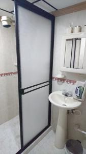 baño con puerta de ducha y lavamanos en Apartamento Rosita en Jardin