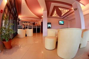 a lobby with white stools and a bar at Hotel Akre in Kavarna