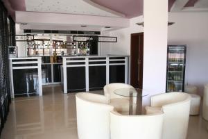 a bar with white chairs and a glass table at Hotel Akre in Kavarna