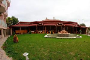 a large building with a fountain in the middle of a yard at Hotel Akre in Kavarna