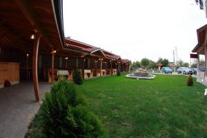 a building with a green yard with a fountain at Hotel Akre in Kavarna