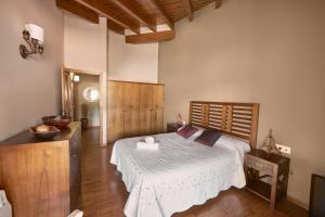 a bedroom with a large bed with a wooden headboard at Desconnectar Bellver de Cerdanya I in Bellver de Cerdanya 