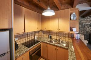a kitchen with wooden cabinets and a sink at Desconnectar Bellver de Cerdanya I in Bellver de Cerdanya 