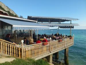 a group of people sitting at a restaurant next to the ocean at Hotel Akre in Kavarna