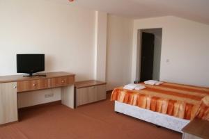 a hotel room with a bed and a flat screen tv at Hotel Akre in Kavarna