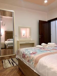 a bedroom with a large bed and a mirror at Apartments Albin in Ulcinj