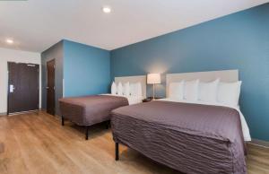 a hotel room with two beds and a blue wall at WoodSpring Suites Allentown in Allentown +41 photos