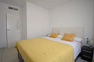 una camera da letto con un grande letto con lenzuola gialle di Hillasol vakantiewoning El Pinet Beach a La Marina