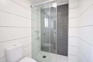 Un baño con inodoro y ducha de cristal. en Hillasol vakantiewoning El Pinet Beach, en La Marina 8 fotos más